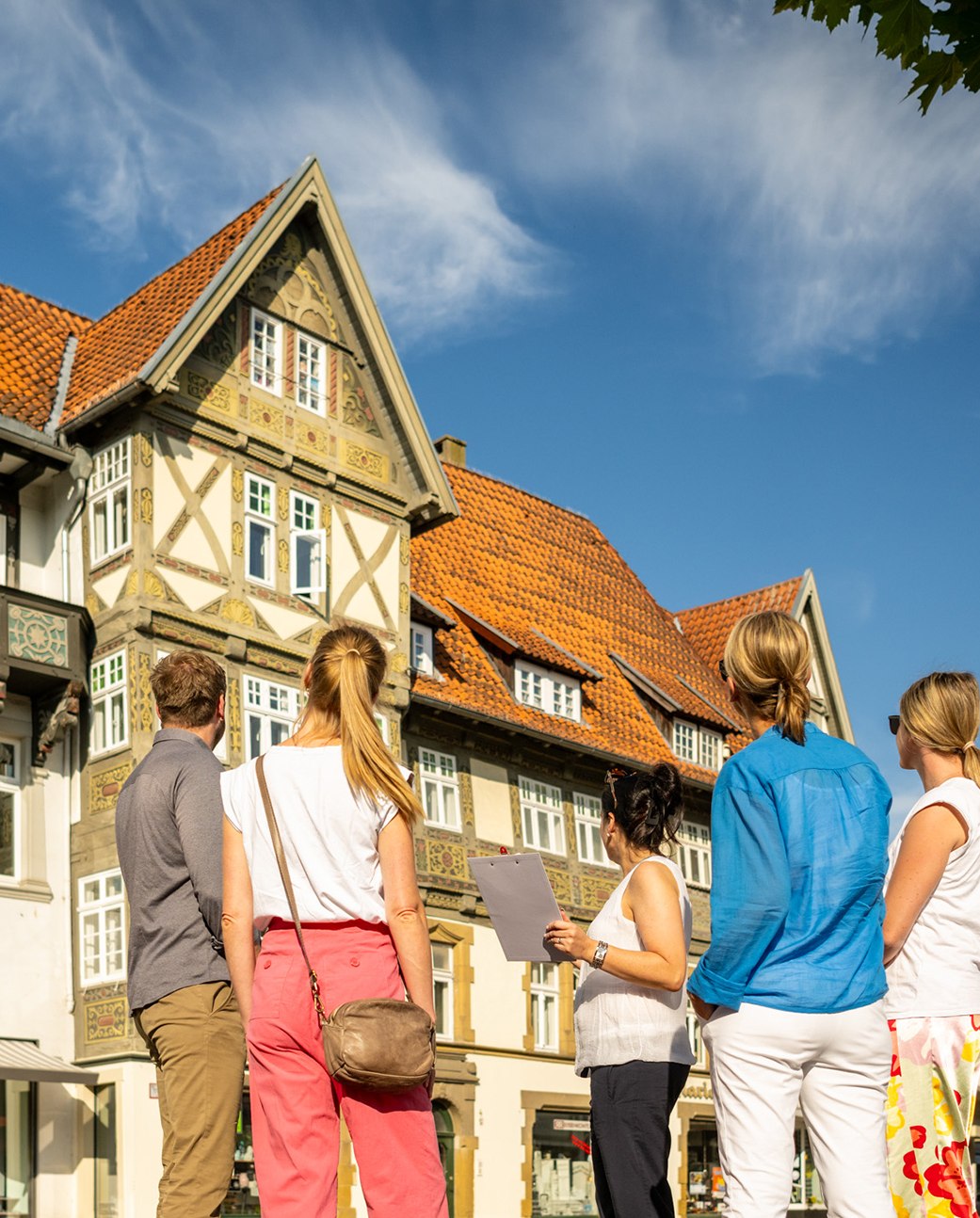 Das Bild zeigt eine kleine Gruppe Teilnehmende einer Stadtführung und die Stadtführerin