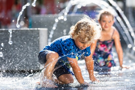 Spielende Kinder im Springbrunnen
