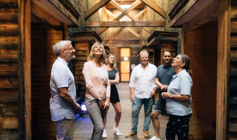 Stadtführung Bad Salzuflen im Gradierwerk Eine Gruppe von Menschen steht im Elebnis-Gradierwerk und lauscht den Ausführungen der Stadtführerin
