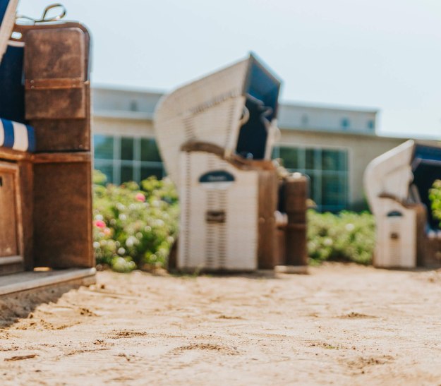 Strandk&ouml;rbe stehen im Kurpark auf Sandboden: Entspannung f&uuml;r Barf&uuml;&szlig;e