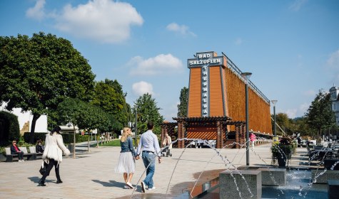 Flanieren am Gradierwerk Parkstraße - im Hintergrund sehen Sie den Rosengarten - im Vordergrund das Wasserspiel am Schliepsteiner Tor., © Staatsbad Salzuflen GmbH / S. Strothbäumer