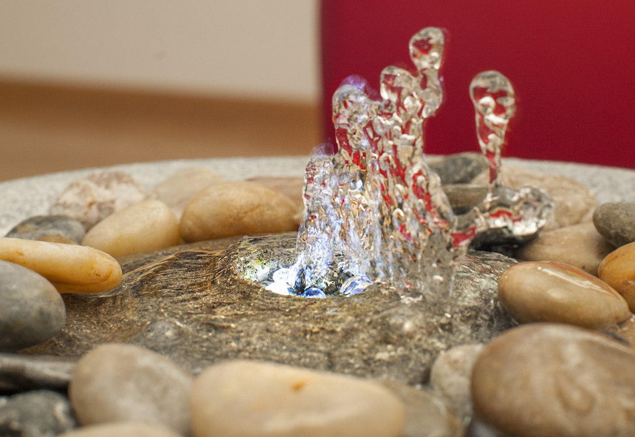 Besondere Wohlfühlatmosphäre: Das Plätschern des Wassers ist belebend und beruhigend zugleich. Ein Brunnen erinnert an sprudelnde Quellen im Wald oder plätschernde Bergbächlein. Sie verbessern die Raumluft, erhöhen die Luftfeuchtigkeit und das Plätschern des Wassers wirkt sich positiv auf unser Wohlbefinden aus., © IN-TI Institut für Tinnitus Diagnostik und Therapie GmbH