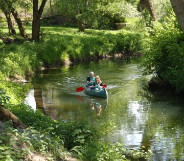 2 Personen paddeln im Kanadier auf einem Fluss