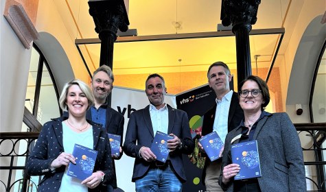 Mehrere Personen präsentieren das gedruckte Programm der VHS, © Stadt Bad Salzuflen