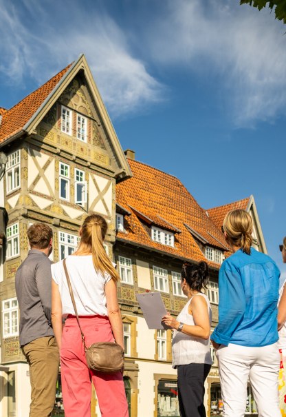 Das Bild zeigt eine kleine Gruppe Teilnehmende einer Stadtführung und die Stadtführerin