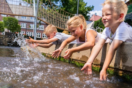 3 Kinder spielen mit dem Wasser der Salze