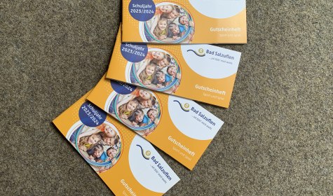 Vier Gutscheinhefte &quot;Spiel und Sport&quot; liegen aufgefächert auf einem Filzboden, © Stadt Bad Salzuflen