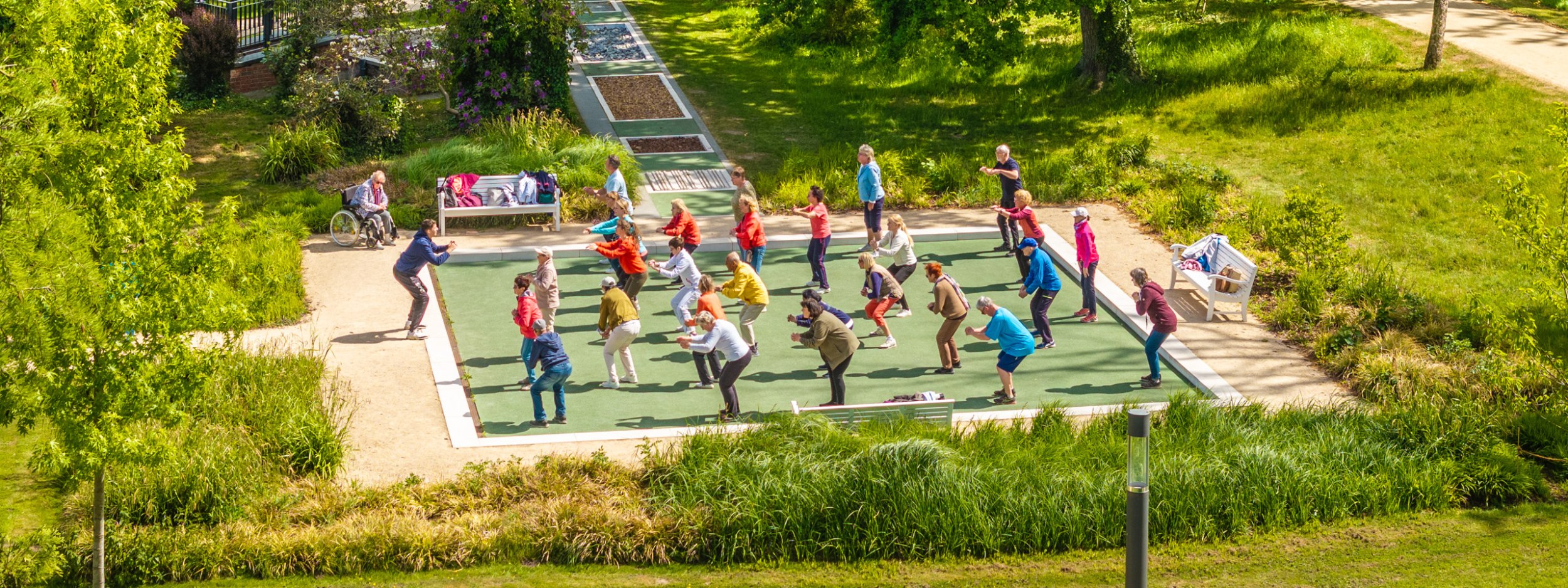 Drohnenaufnahme einer Sportgruppe im Kurpark bei der Gymnastik