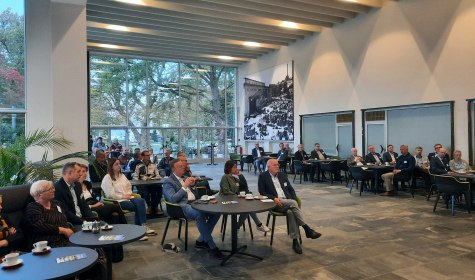 Mehrere Personen sitzen auf Stühlen und an Tischen in der Wandelhalle, es handelt sich um Teilnehmende am Dialogformat &quot;Klartext&quot; der Wirtschaftsförderung der Stadt